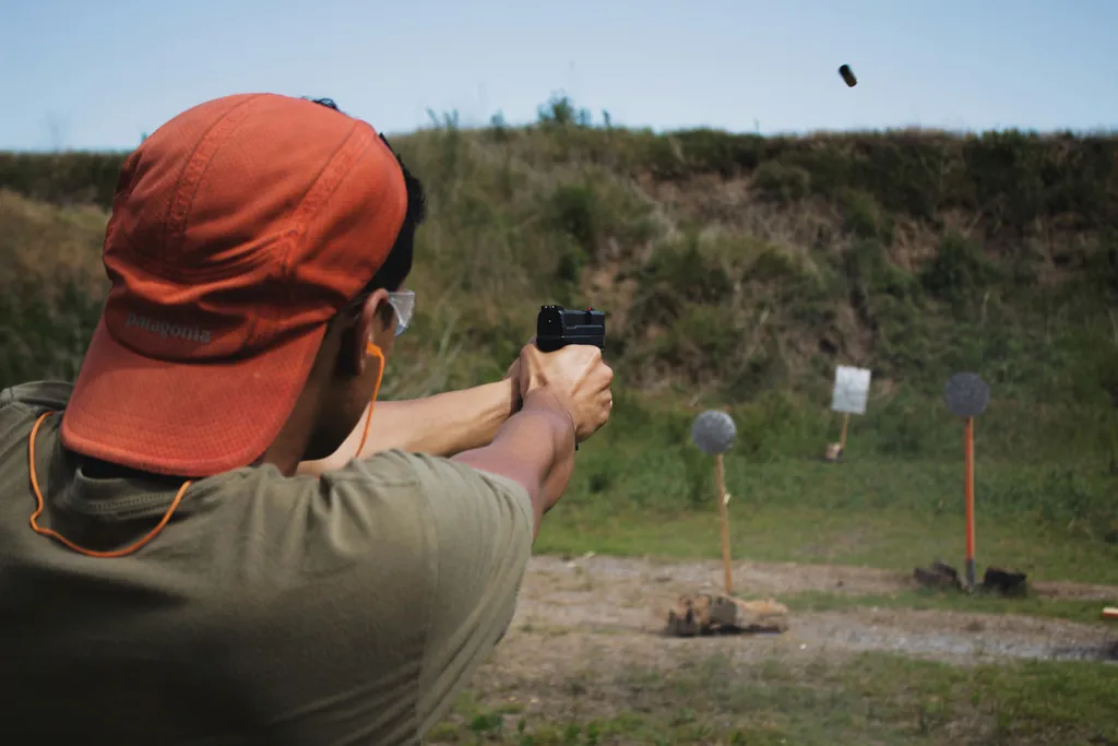 Man firing a gun at a shooting range target